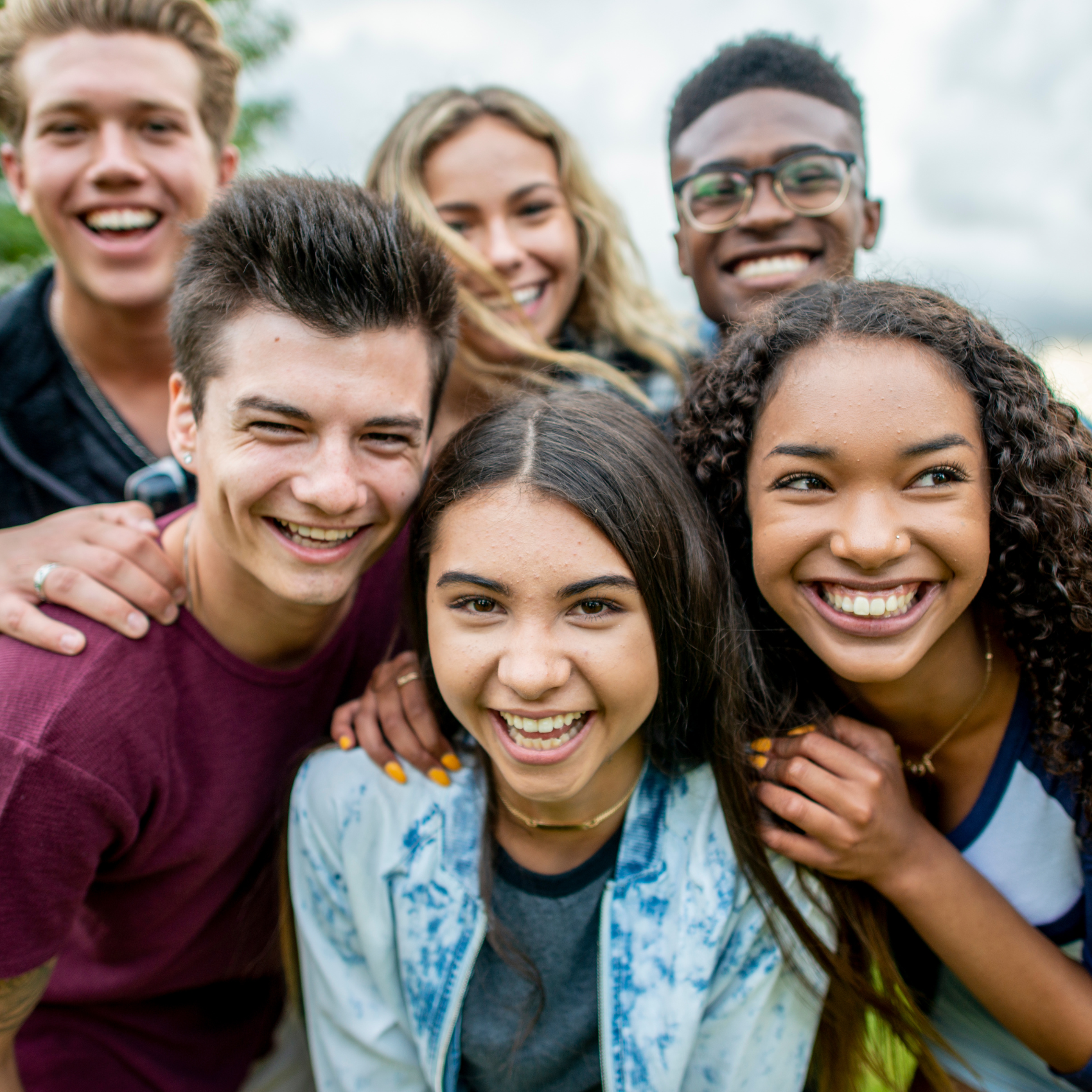 A diverse group of happy needs, smiling into the camera